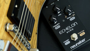 Neunaber Echelon Echo pedal on a table next to a guitar