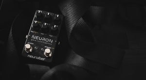 Neunaber Neuron Gain pedal surrounded by guitar straps